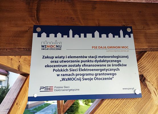 Tabliczka informacyjna nt. realizacji projektu zamontowana pod wiatą.